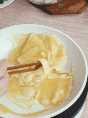 油6成熱時(shí)，下雞蛋液，邊緣凝固時(shí)翻拌成塊狀。